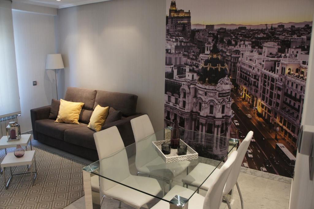 马德里阿瑞赞尼卡套房公寓的客厅配有玻璃桌和沙发