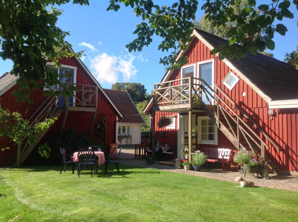 恩厄尔霍尔姆Gånarps rum och Stuguthyrning的院子里的红色房子,配有桌椅