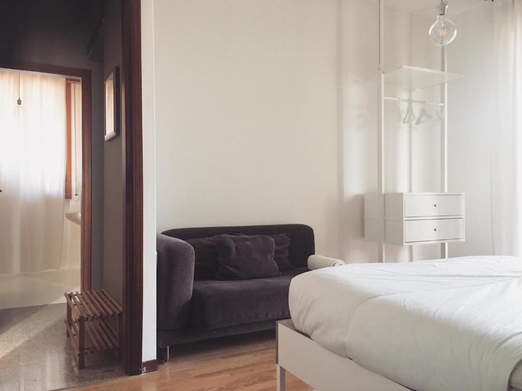 皮耶韦埃马努埃莱Sunny family apartment in villa - HUMANITAS FORUM IEO的一间卧室配有一张床和一张沙发
