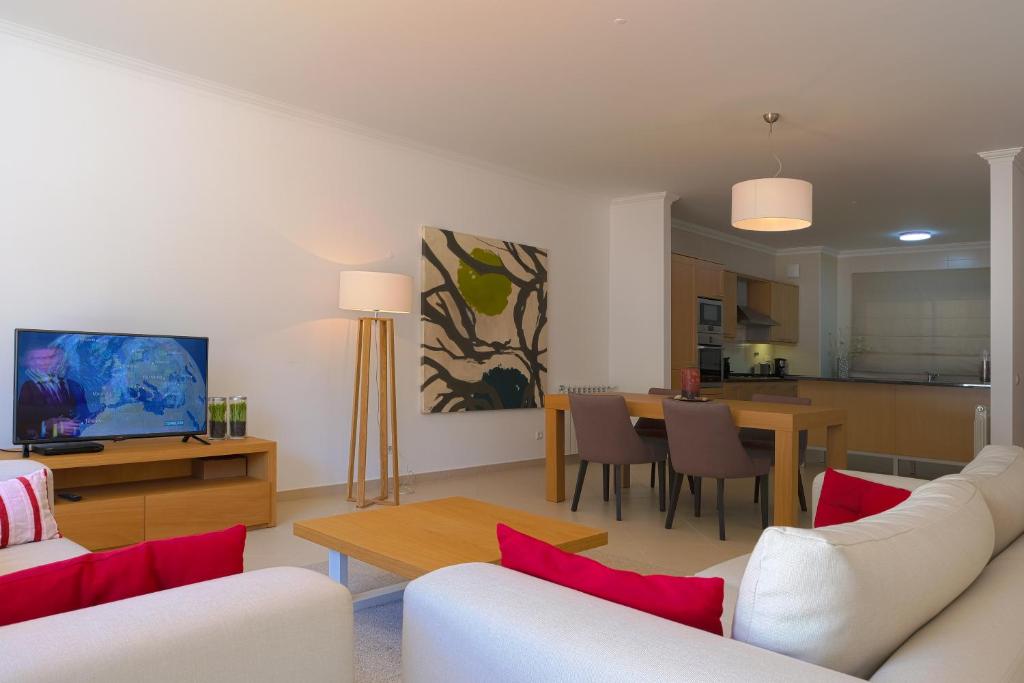 奥比多斯Confortavel T2的一间带白色家具的客厅和一间餐厅