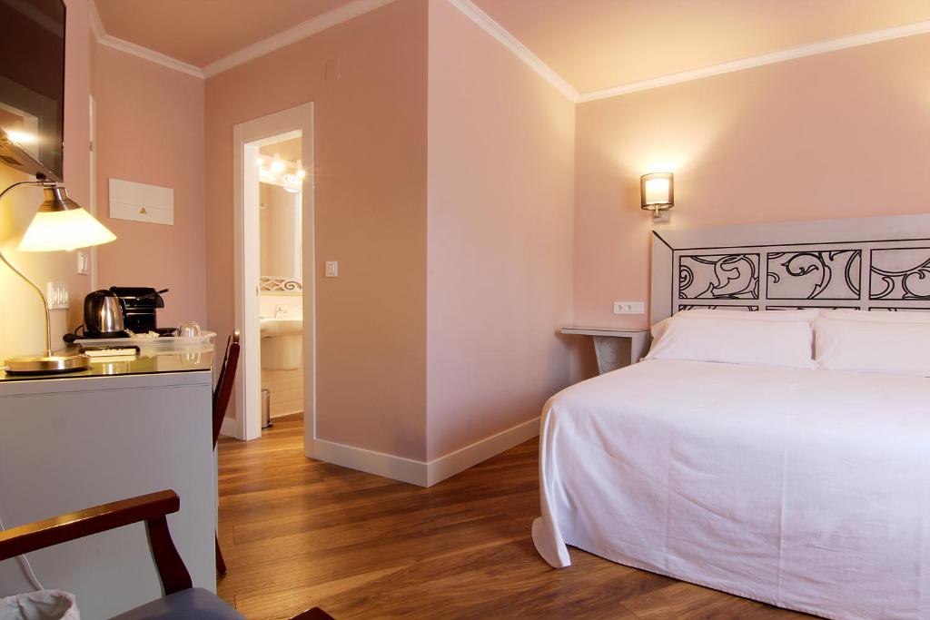 坎德莱达卡斯塔罗斯旅馆的一间带白色床的卧室和一间浴室