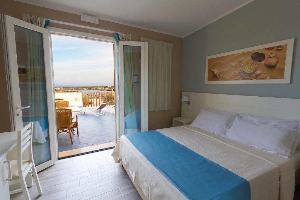 兰佩杜萨Le Anfore Hotel - Lampedusa的一间卧室设有一张床和一个美景阳台
