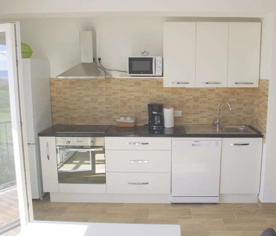 卡什泰拉Apartment LuMaGo的厨房配有白色橱柜和水槽