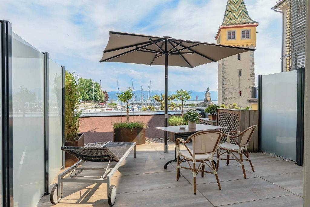 林道Apartment Hotel Schreier的庭院配有桌椅和遮阳伞。