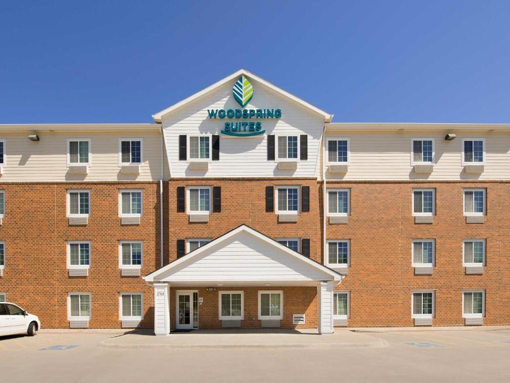 贝尔维尤WoodSpring Suites Omaha Bellevue, an Extended Stay Hotel的一座大型红砖建筑,上面有标志