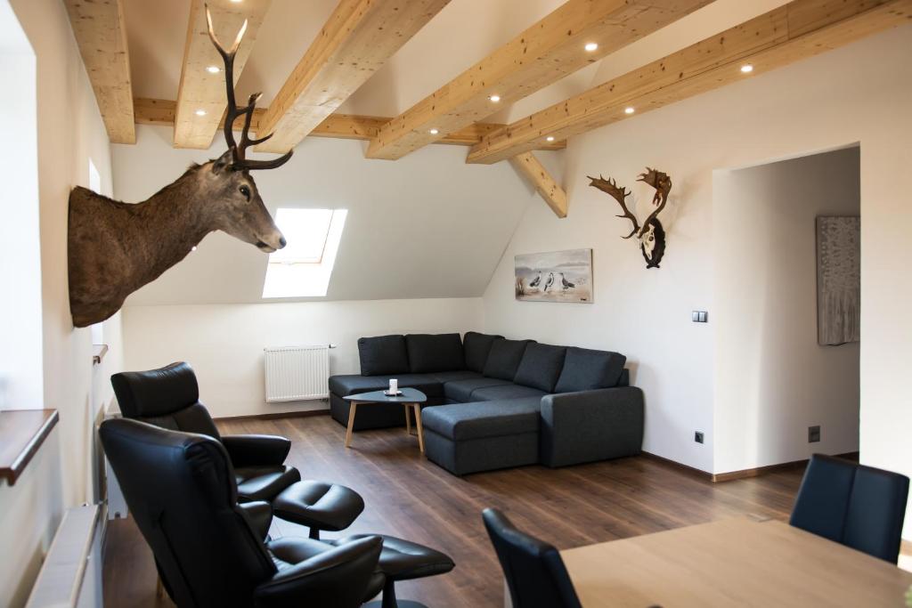 斯拉沃尼采Hotel Hubert的客厅配有沙发和墙上的鹿头