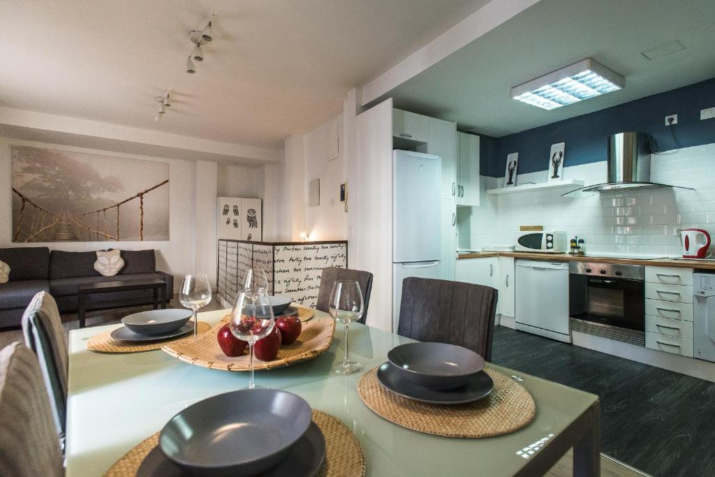 塞维利亚Apartamento Centro Sevilla的厨房以及带桌椅的起居室。