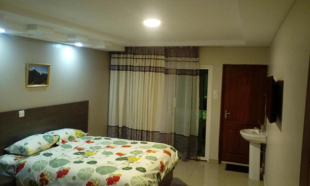 MeruAdala Motel的一间卧室配有床、水槽和卫生间
