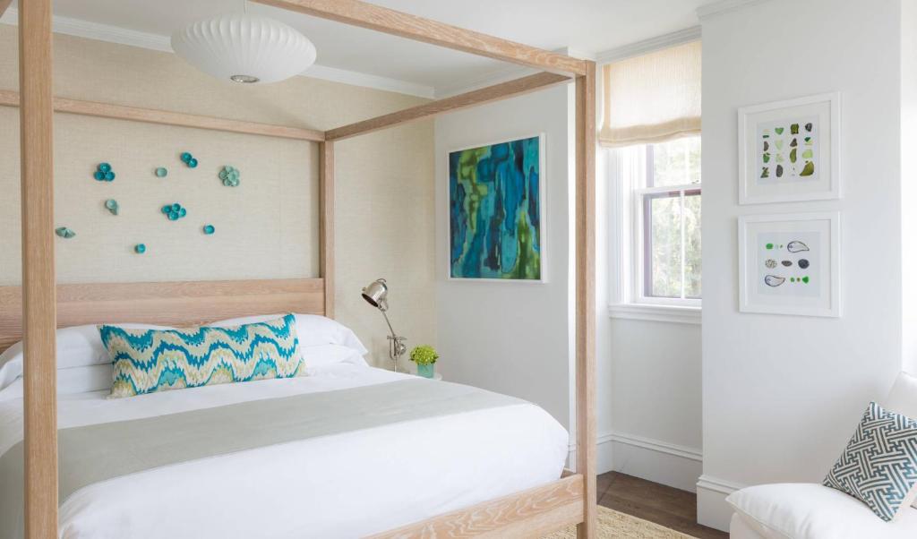 楠塔基特21布罗德酒店的一间卧室设有天蓬床和窗户。