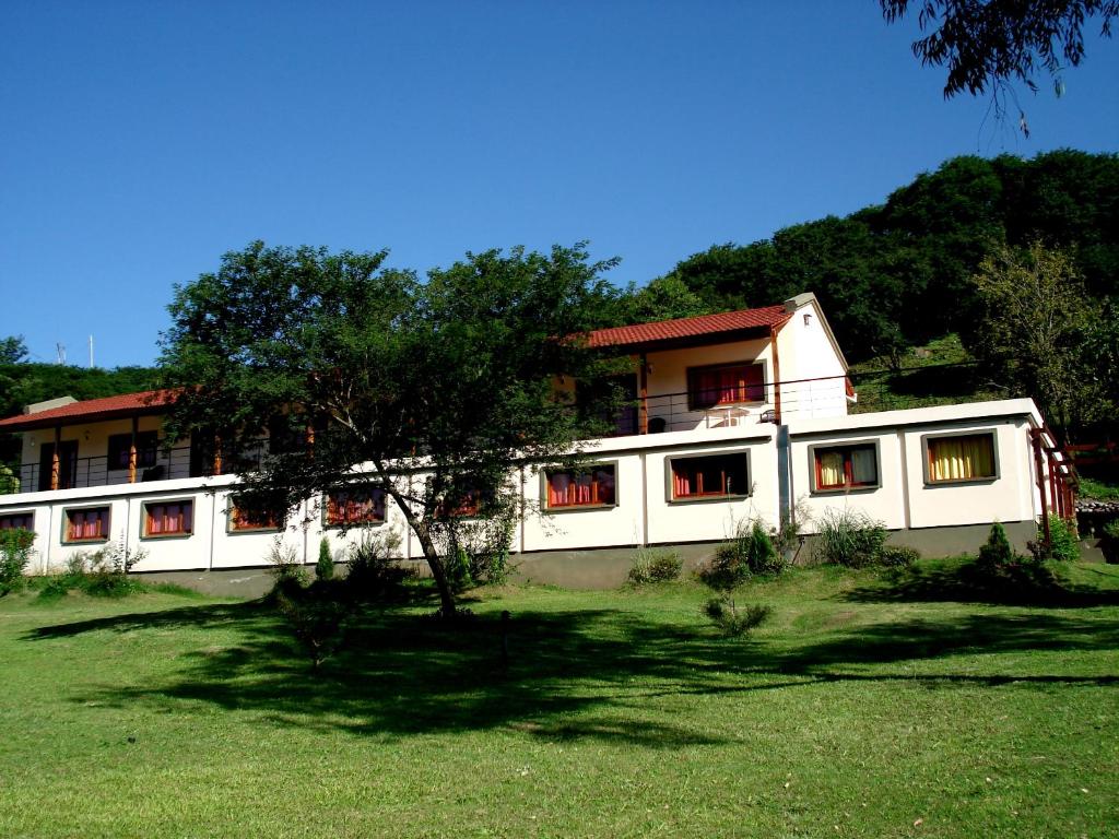 ReyesPura Vida Hosteria的前面有棵树的白色建筑