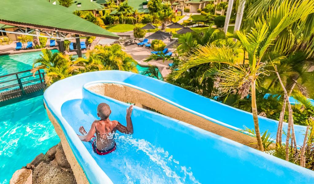 南迪托卡托卡度假酒店的一名在度假村玩水滑梯的男孩