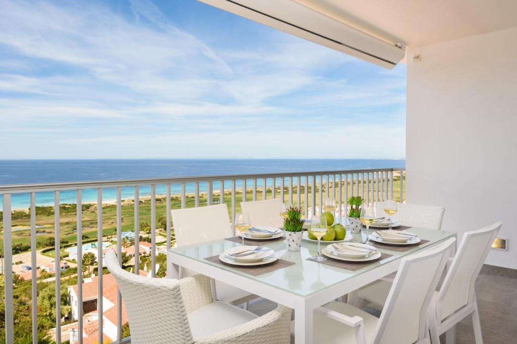 苏昂博Suites Las Vistas by Menorca Vacations的海景阳台上的白色餐桌和椅子