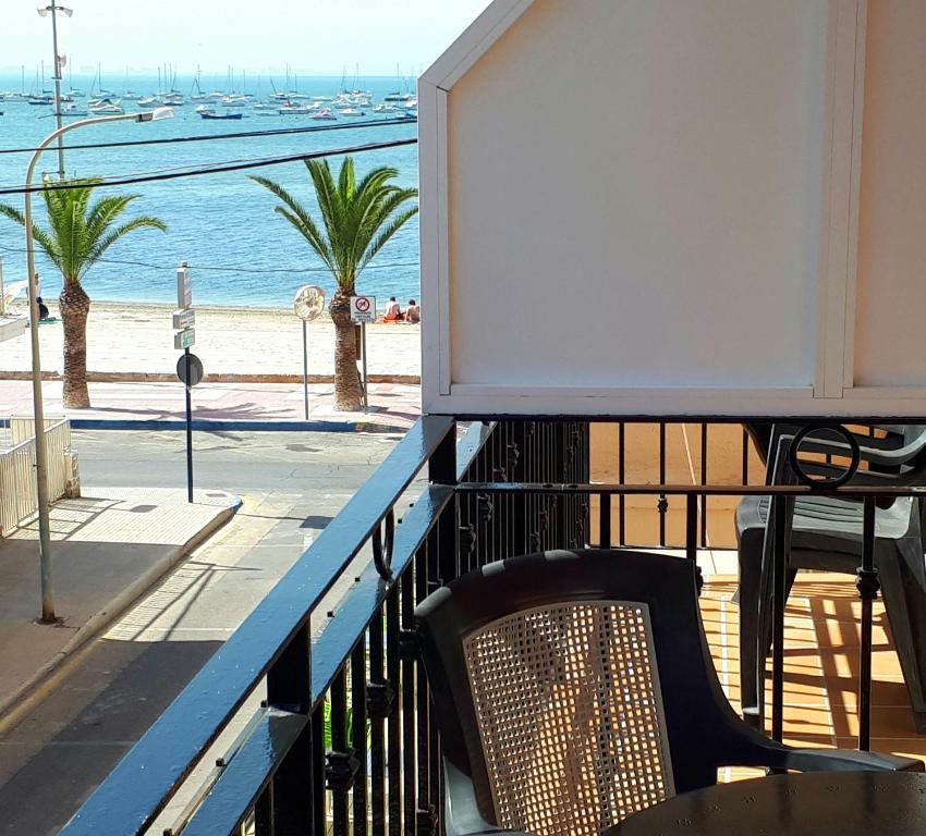 洛帕莞阿拉斯加酒店的一个带桌椅和海滩的阳台