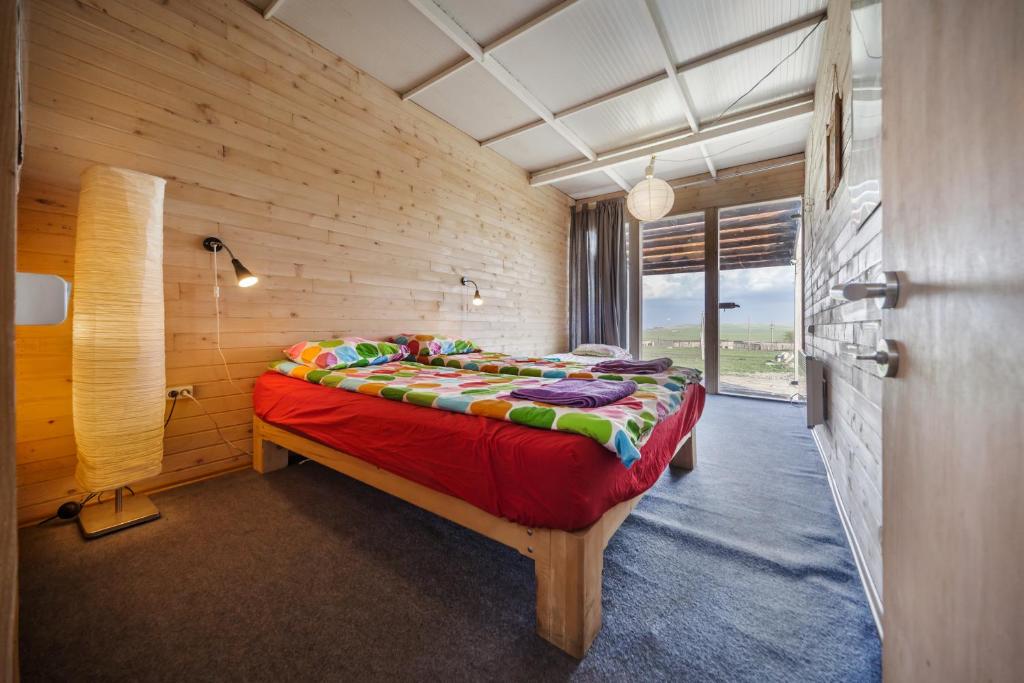 UdabnoOasis Club Cottages的卧室配有木墙内的一张床