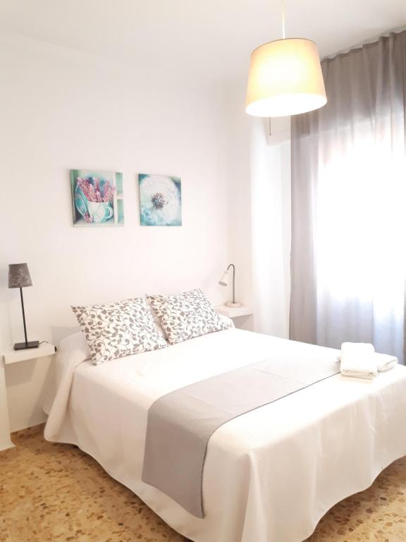 塞埃欣Apartamento Gran Vía Cehegín的白色卧室配有白色的床和灯