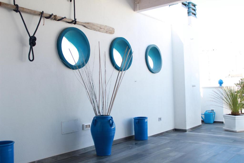 滨海波利尼亚诺乌恩索格诺科西公寓的蓝色的花瓶,墙上有三面镜子