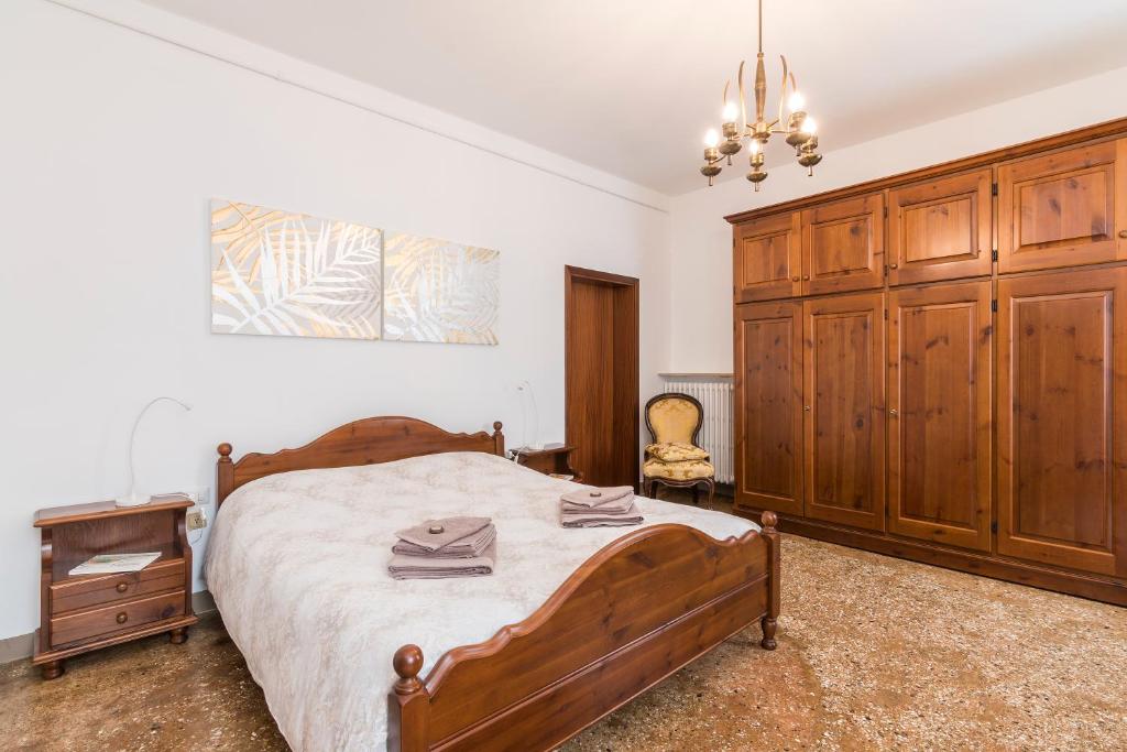 威尼斯Ca' Dada Appartamento的一间卧室配有一张床和一个木制橱柜