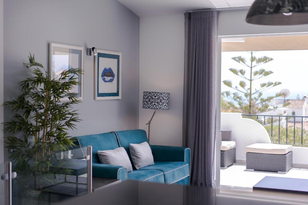卢斯ATLANTIC VIEW Apartment的一间带蓝色沙发的客厅和一个阳台