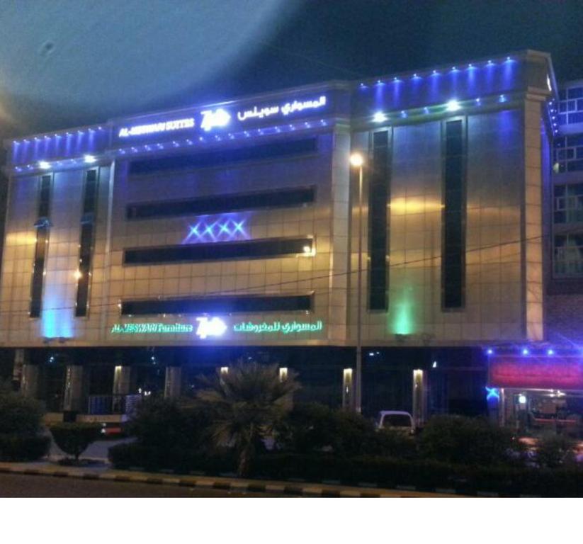 巴哈Almeswari Suites的上面有蓝色的灯的建筑