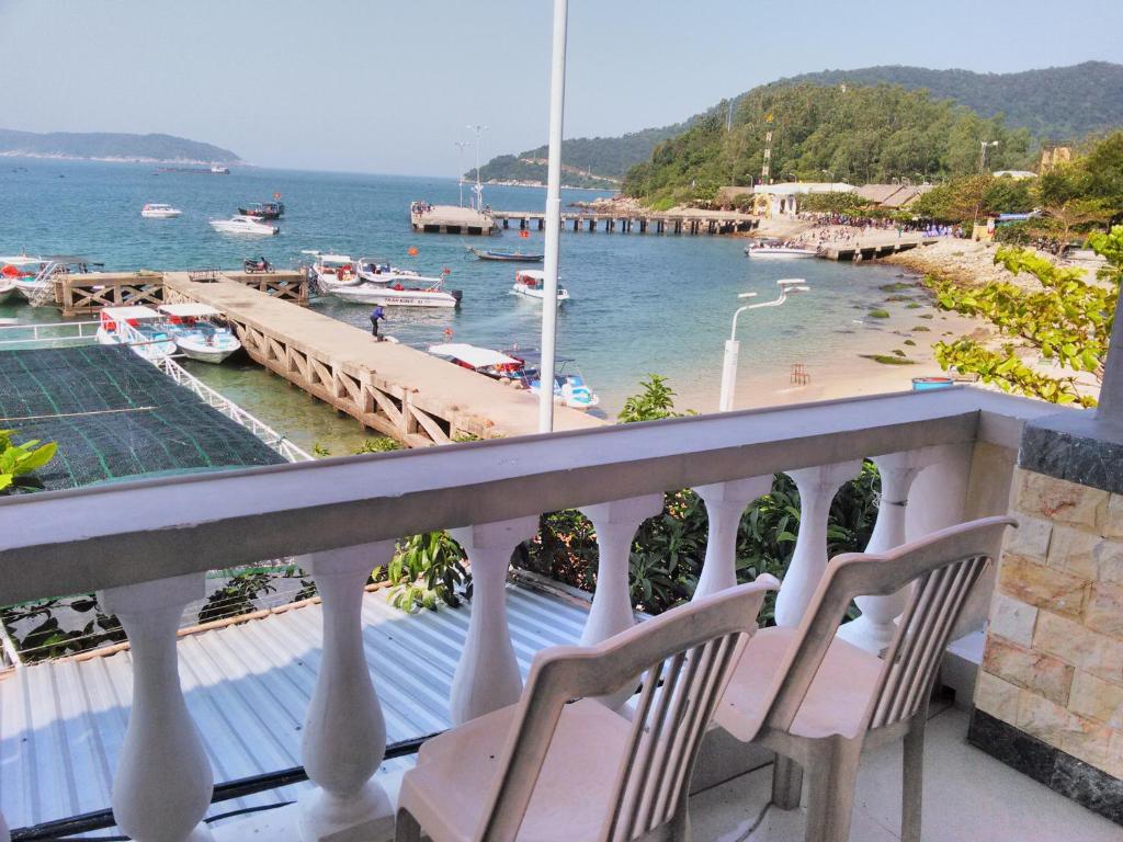 Tân HiệpTuan Thanh Homestay的阳台配有两把椅子,享有水景