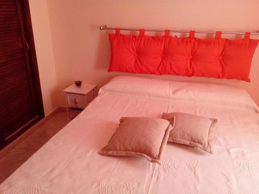 圣米格尔德阿沃纳Sweet Home San Blas的一张白色的床,上面有红色枕头