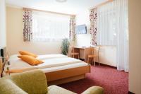 Sankt Martin im Sulmtal格斯玛瑞提旅馆的有两张床和一张书桌的酒店房间