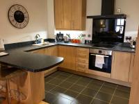 约克Central York Apartment - Skeldergate YO1的厨房配有木制橱柜和黑色台面