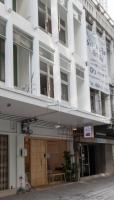 曼谷平托青旅的街道上一栋带阳台的白色建筑