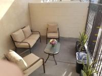 洛杉矶托斯卡纳花园酒店的阳台配有两把椅子、一张沙发和一张桌子