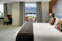 皇后镇Rendezvous Heritage Hotel Queenstown的酒店客房,设有一张大床,享有山景