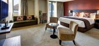 皇后镇Rendezvous Heritage Hotel Queenstown的一间配有床、沙发和桌子的酒店房间
