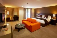 皇后镇Rendezvous Heritage Hotel Queenstown的酒店客房,配有床和橙色椅子