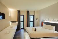 略夫雷加特河畔奥斯皮塔莱特easyHotel Barcelona Fira的有两张床和一扇窗户的酒店房间