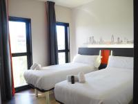 略夫雷加特河畔奥斯皮塔莱特easyHotel Barcelona Fira的有两张床的房间有两扇窗户