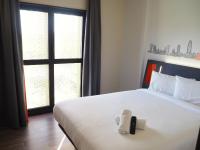 略夫雷加特河畔奥斯皮塔莱特easyHotel Barcelona Fira的一间卧室配有一张带遥控器的床