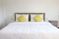 库德岛The Lodge at Koh Kood的白色的床,配有白色床单和黄色枕头