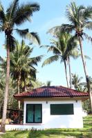 库德岛The Lodge at Koh Kood的一座棕榈树成荫的白色小房子