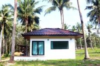 库德岛The Lodge at Koh Kood的一座棕榈树成荫的白色小房子