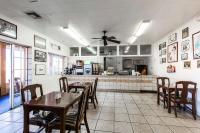 金曼Rodeway Inn Kingman Route 66的一间有桌椅和厨房的餐厅
