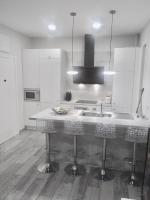 马德里Apartamento estilo nórdico en Malasaña (Madrid Centro)的带水槽和带凳子的柜台的厨房