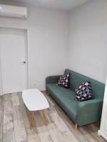 马德里Apartamento estilo nórdico en Malasaña (Madrid Centro)的客厅里有一张绿色的沙发和一张桌子