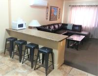 佩吉Lake Powell Motel &amp; Apartments的客厅设有带凳子和沙发的酒吧