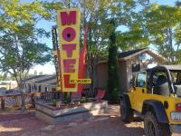 佩吉Lake Powell Motel &amp; Apartments的停在标志前的黄色吉普车