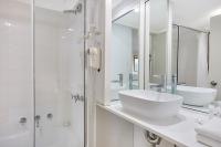 悉尼Renovated Stylish Studio的带水槽和淋浴的白色浴室