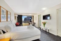 悉尼Renovated Stylish Studio的酒店房间里有一张白色的大床和一张桌子