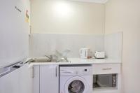 悉尼Renovated Stylish Studio的白色的厨房配有洗衣机和水槽
