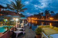 帕拉蒂Pousada Casa do Rio Hostel - 8 min do Centro Hístorico - Passeio de Barco com saída da Pousada -Pago a parte- Perto das Praias e Beira Rio的河畔甲板上配有沙发和桌椅