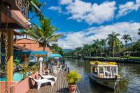 帕拉蒂Pousada Casa do Rio Hostel - 8 min do Centro Hístorico - Passeio de Barco com saída da Pousada -Pago a parte- Perto das Praias e Beira Rio的一条河,船停靠在度假村旁边