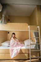 清迈帕克平旅舍的坐在双层床上的一个女人