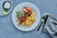 阿布扎比Premier Inn Abu Dhabi Airport Business Park的盘子的食物,包括意大利面、肉和薯条